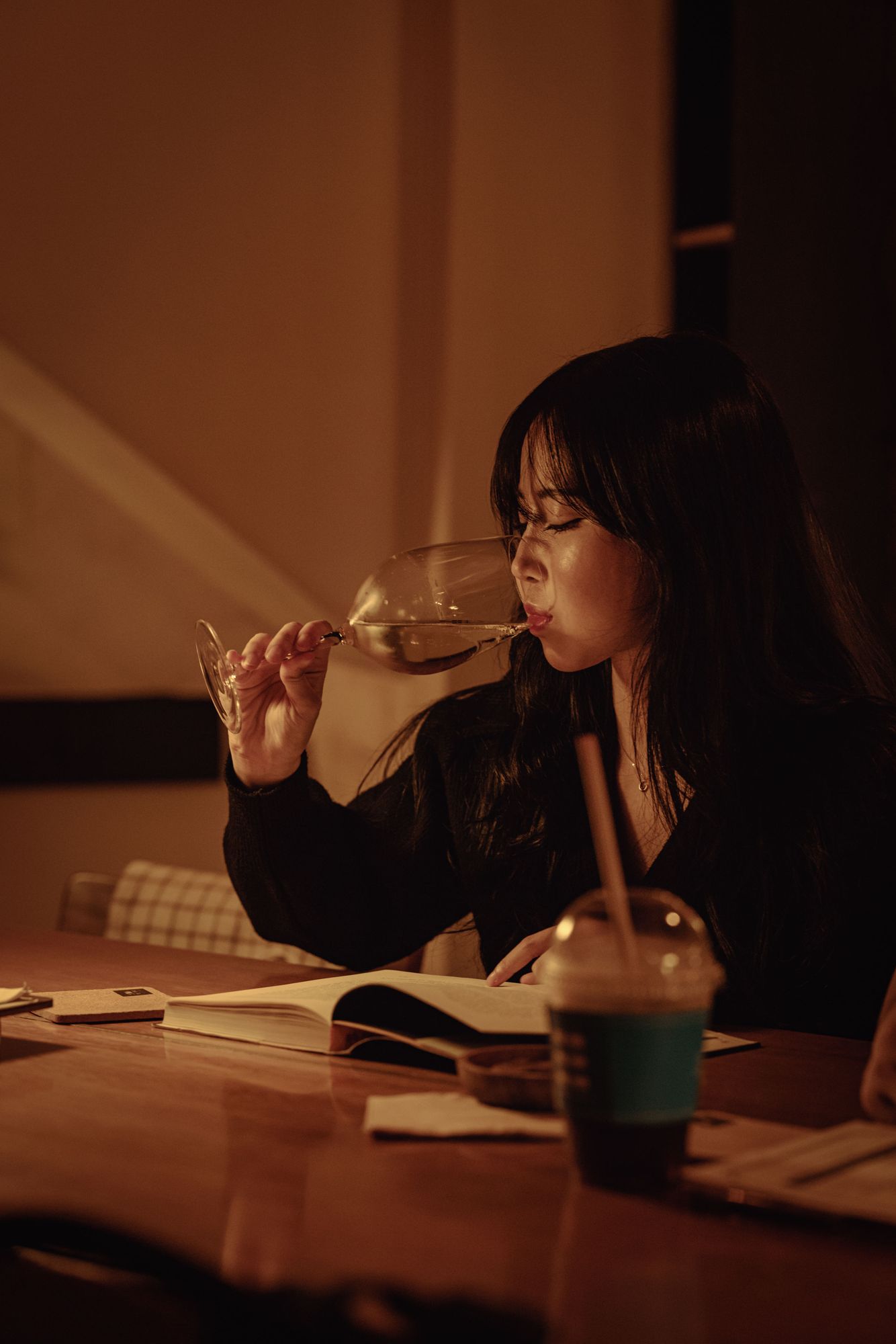 책을 펼쳐 두고 와인 잔을 기울이는 손님